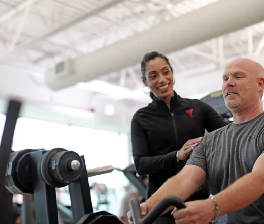 Staff assisting member lifting weights