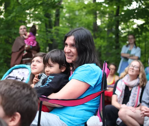 Mother and son sitting around group camp fire