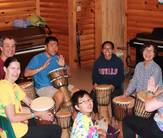 Families in a circle playing on bongo drums
