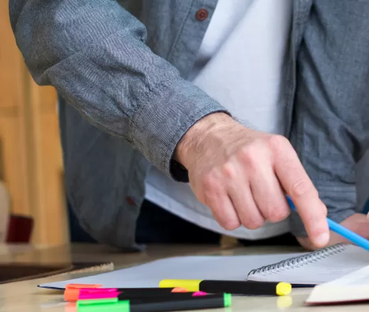Two people reading a book together and discussing.