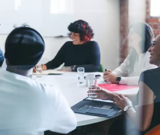 Group of people sitting together around a table speaking