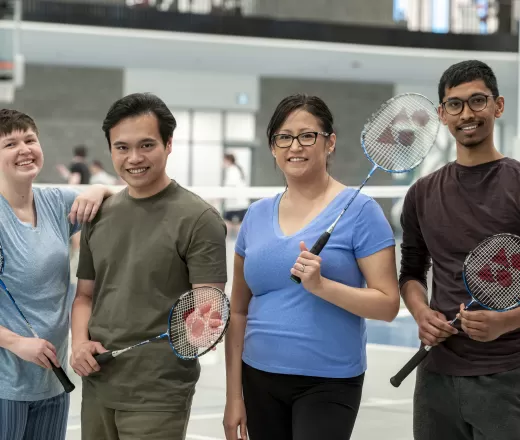 4 individuals holding Badminton racquets