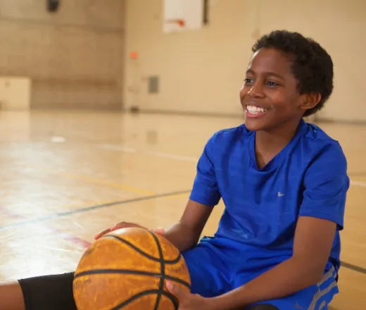 Boy siting on basketball court
