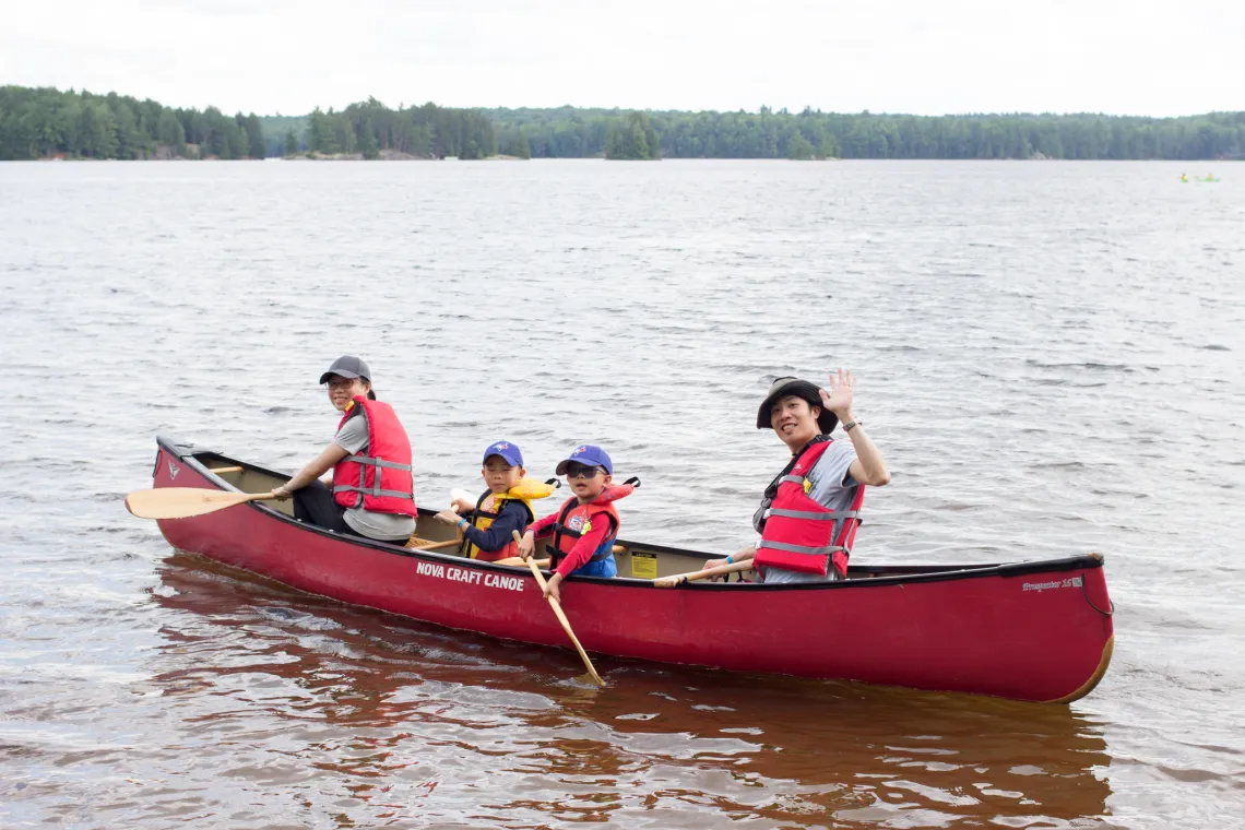 Smiling family in canoe at Wanakita on Koshlong Lake