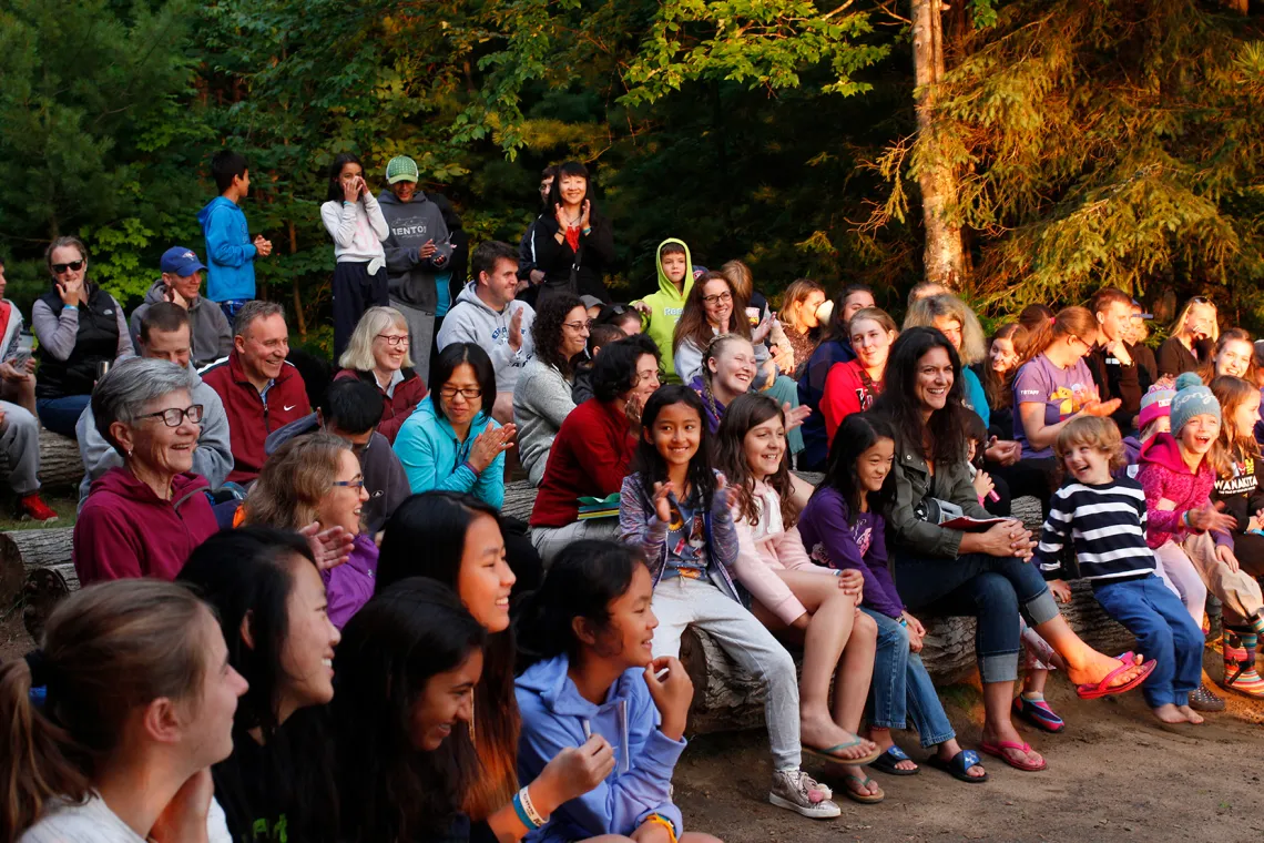 Families sitting around group camp fire
