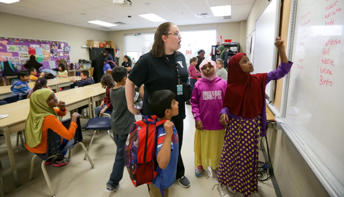 Educator and children writing on white board