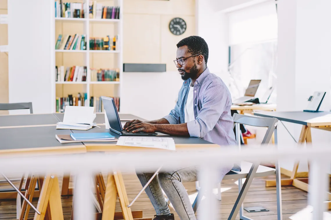 man sitting at computer desk typing