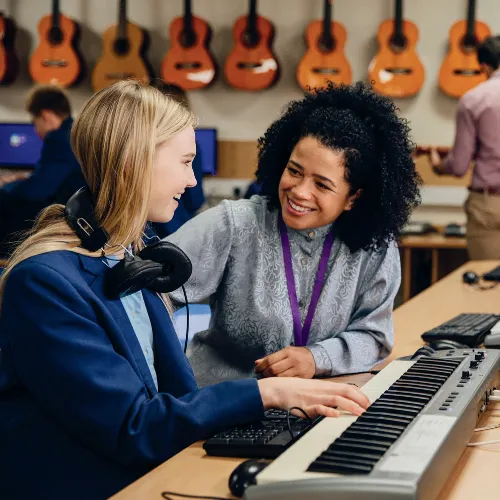 Teacher talking to teen at a piano