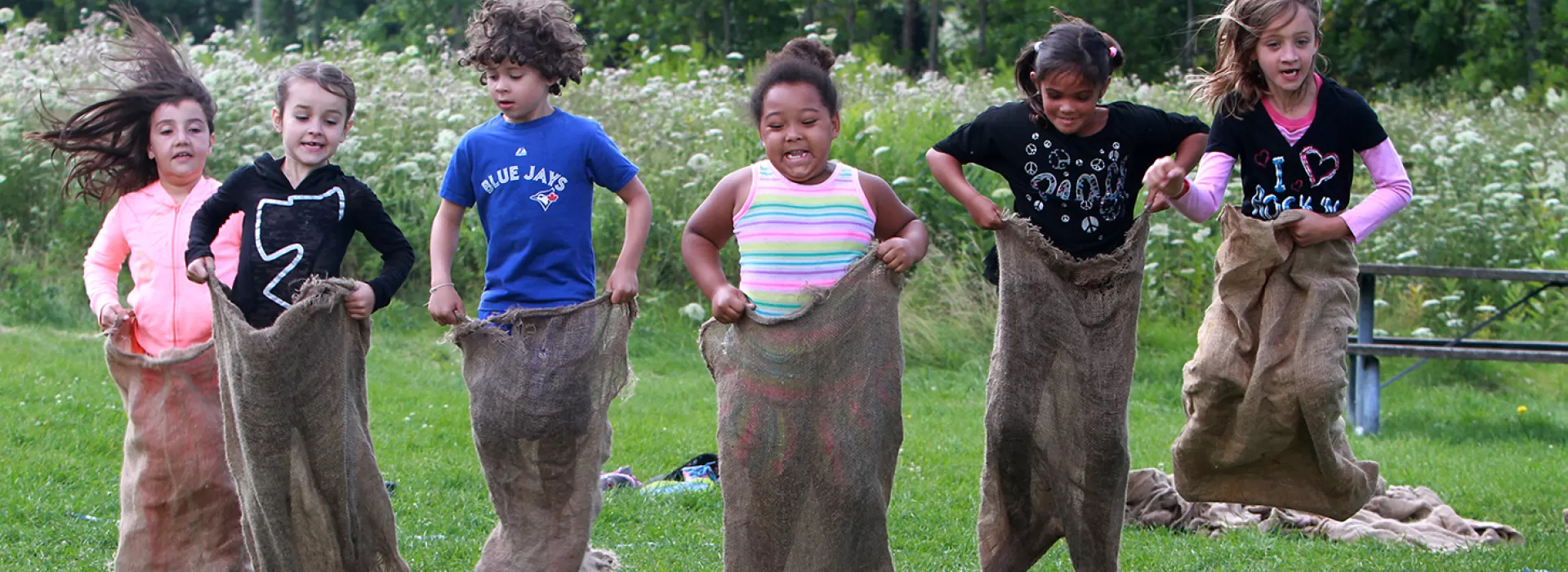 Group of campers in potato sack race