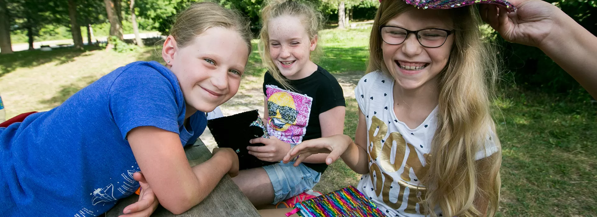 Group of smiling female campers sitting at picnic table