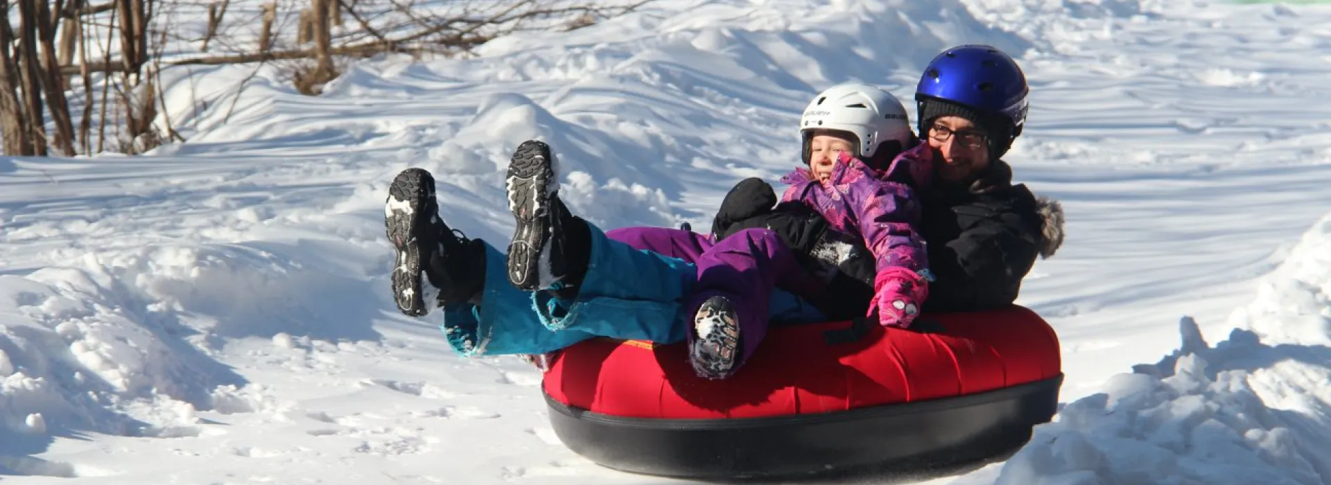 Child and parent tobogganing at camp