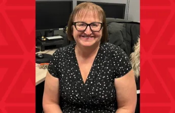 women in black dress sits at desk
