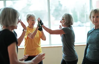 senior women high fiving in gym class