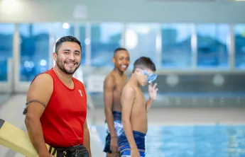 Lifeguard and two boys in front of the pool