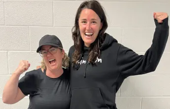 two women wearing black, cheering