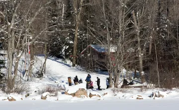 Group of youth in snow woods along shore
