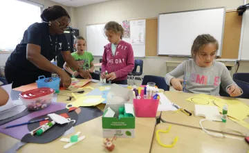 Educator with children crafting at table