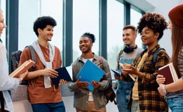 6 young people standing in a  circle talking, smiling.