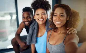 Three young adults take a selfie after a workout
