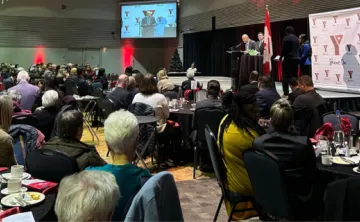 People sitting at tables watching the speaker talk at PeaceMedal