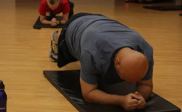 Man does plank during fitness class