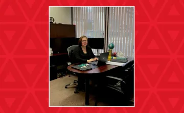 Woman sits in her office working on a laptop