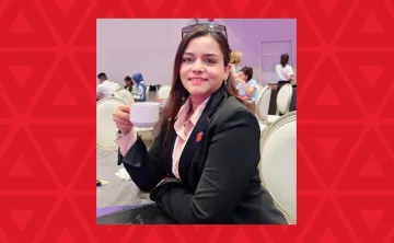 woman holding coffee cup sitting at table
