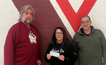 two men and a women stand in font of YMCA logo