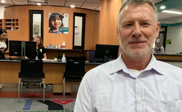  Smiling Older man sits in front of membership desk