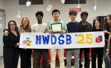 high school students hold banner that says HWDSB 2025 Food Drive