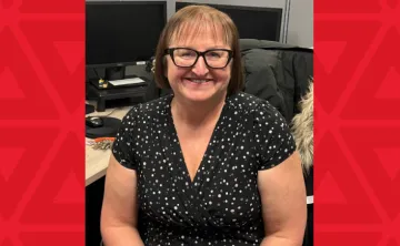 women in black dress sits at desk