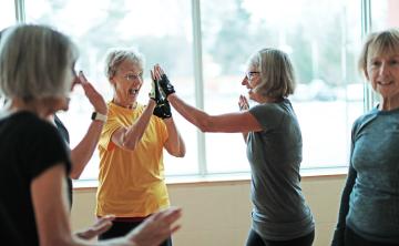 senior women high fiving in gym class