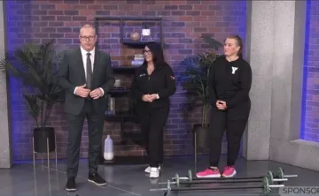 Man and two women in a news segment standing in front of small barbells 