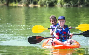 boys in kayak on lake