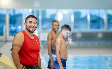 Lifeguard and two boys in front of the pool