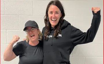 two women wearing black, cheering